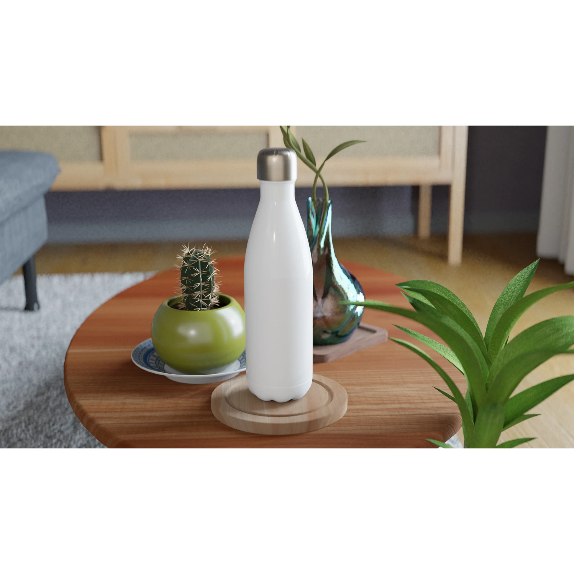Personalisierte weiße Edelstahl-Trinkflasche auf einem Tisch, umgeben von Pflanzen und Dekoration.
