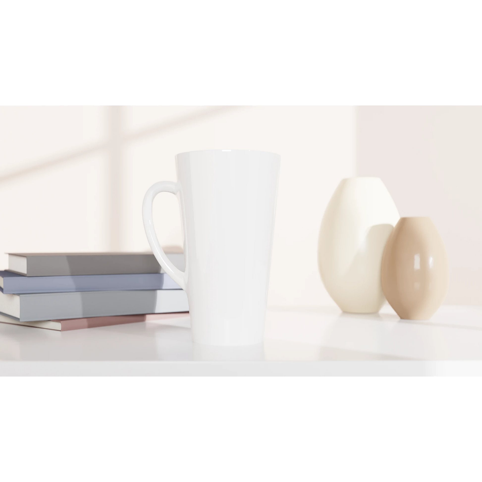 Weiße, personalisierbare Latte-Tasse auf einem Tisch neben Büchern und Vasen, ideal für kreative Designs.
