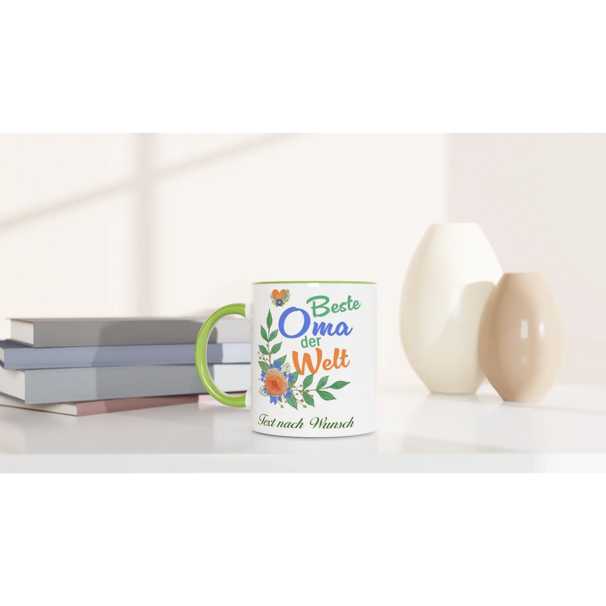 A Tasse mit Herz, featuring Beste Oma der Welt and customizable text, adorned with floral designs, is the perfect personalisierbares Geschenk for your Großmutter. It sits elegantly on a table among books and ceramic vases in soft lighting.