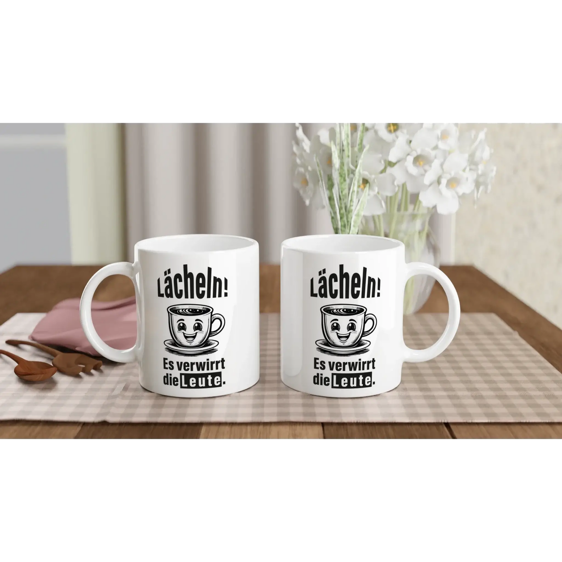 Auf einer karierten Tischdecke stehen zwei weiße Tassen von „Tasse mit Herz“ mit Cartoon-Gesichtern und dem deutschen Text „Lächeln! Es ist verrückt die Leute“, die eine humorvolle Tasse ergänzen. Weiße Blumen und ein rosa Notizbuch sorgen für Charme – ein perfektes Geschenk für Fans des Frecher-Spruchs mit dem Spruch „☕️ Lächeln! Verwirre die Welt.“ 📚🌸.