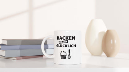 "Backen macht glücklich"-Tasse dekorativ platziert mit Vasen und Büchern im Hintergrund