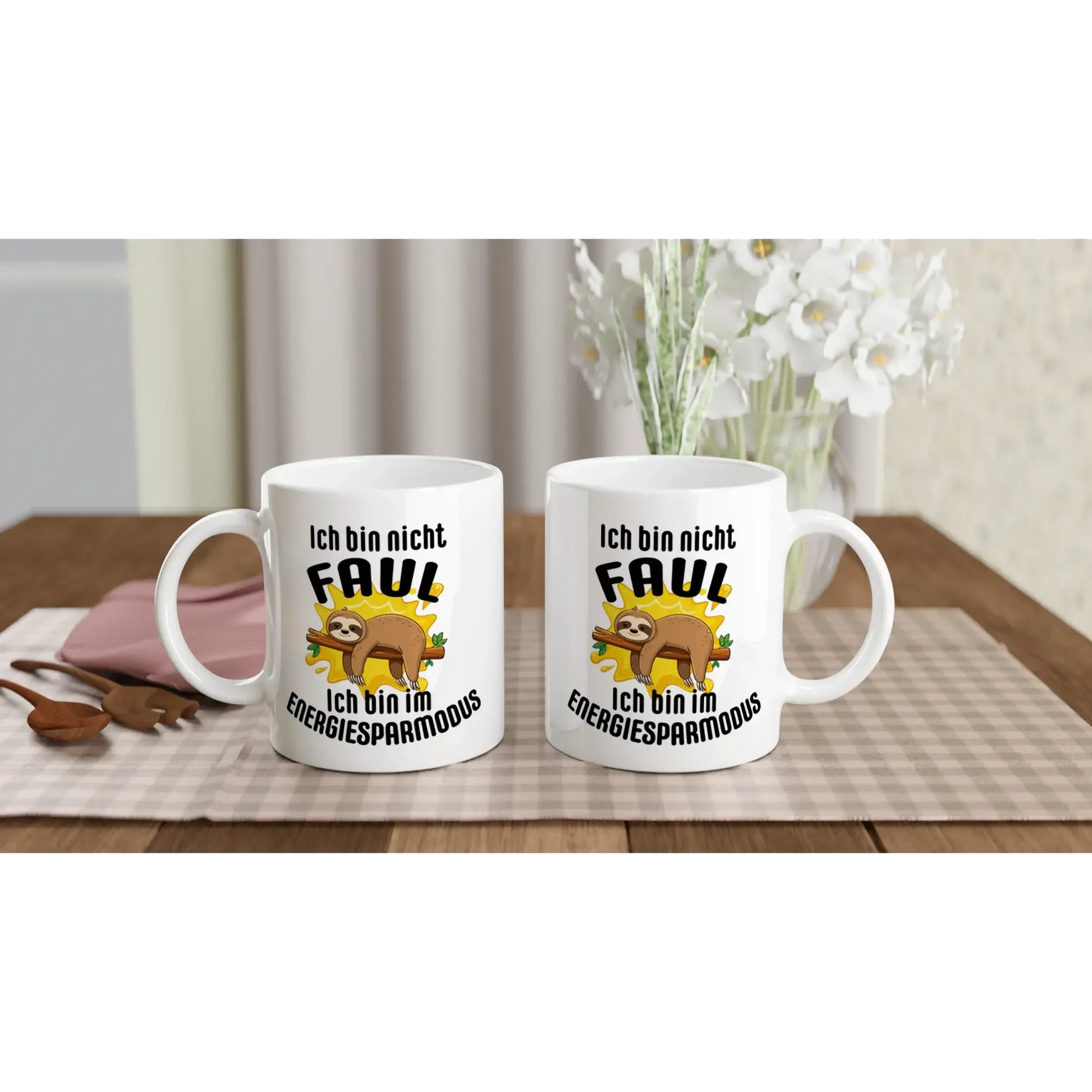Zwei weiße Tassen von Tasse mit Herz auf einer karierten Tischdecke. Jede Tasse zeigt ein Cartoon-Faultier und den deutschen Text „Ich bin nicht faul. Ich bin im Energiesparmodus“. Passend zum Strauß weißer Blumen und Utensilien im Hintergrund. Perfekt als ☕️ Humorvoller Kaffeebecher für entspannte Momente! 😴.
